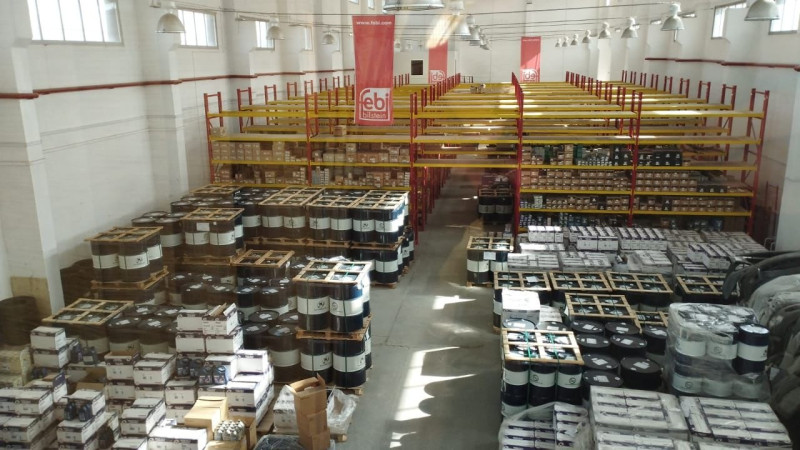 Склад автозапчастей с запасами масла Kuttenkeuler и других продуктов, организованными на стеллажах и паллетах.
